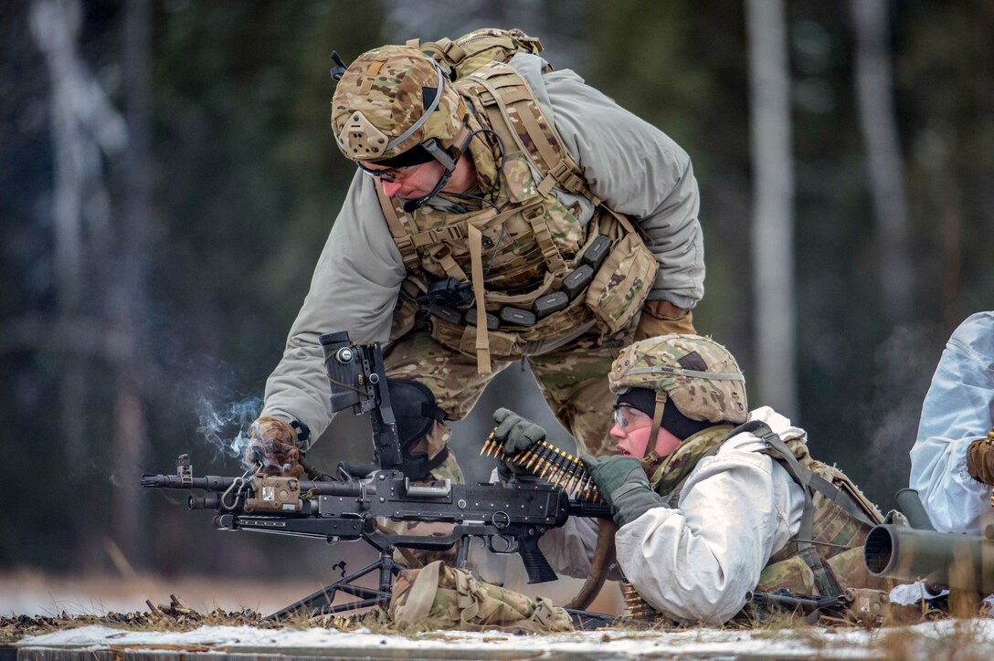 A soldiers inspects another soldier's gun during live-fire training.