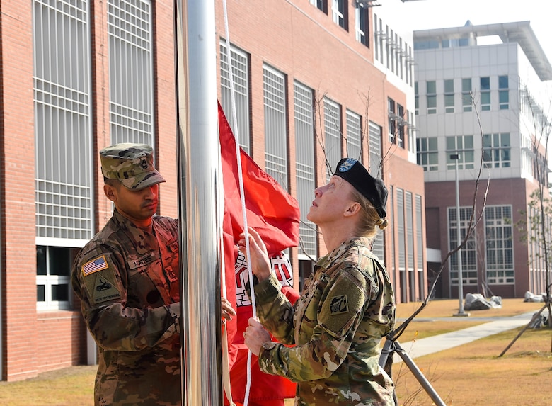 Col. Teresa Schlosser (right), U.S. Army Corps of Engineers (USACE), Far East District (FED) commander, and Richard Byrd (left), USACE FED Deputy District Engineer, prepare to unfurl the unit's colors during an uncasing ceremony held at the district's headquarters, Camp Humphreys, South Korea, Nov. 14.