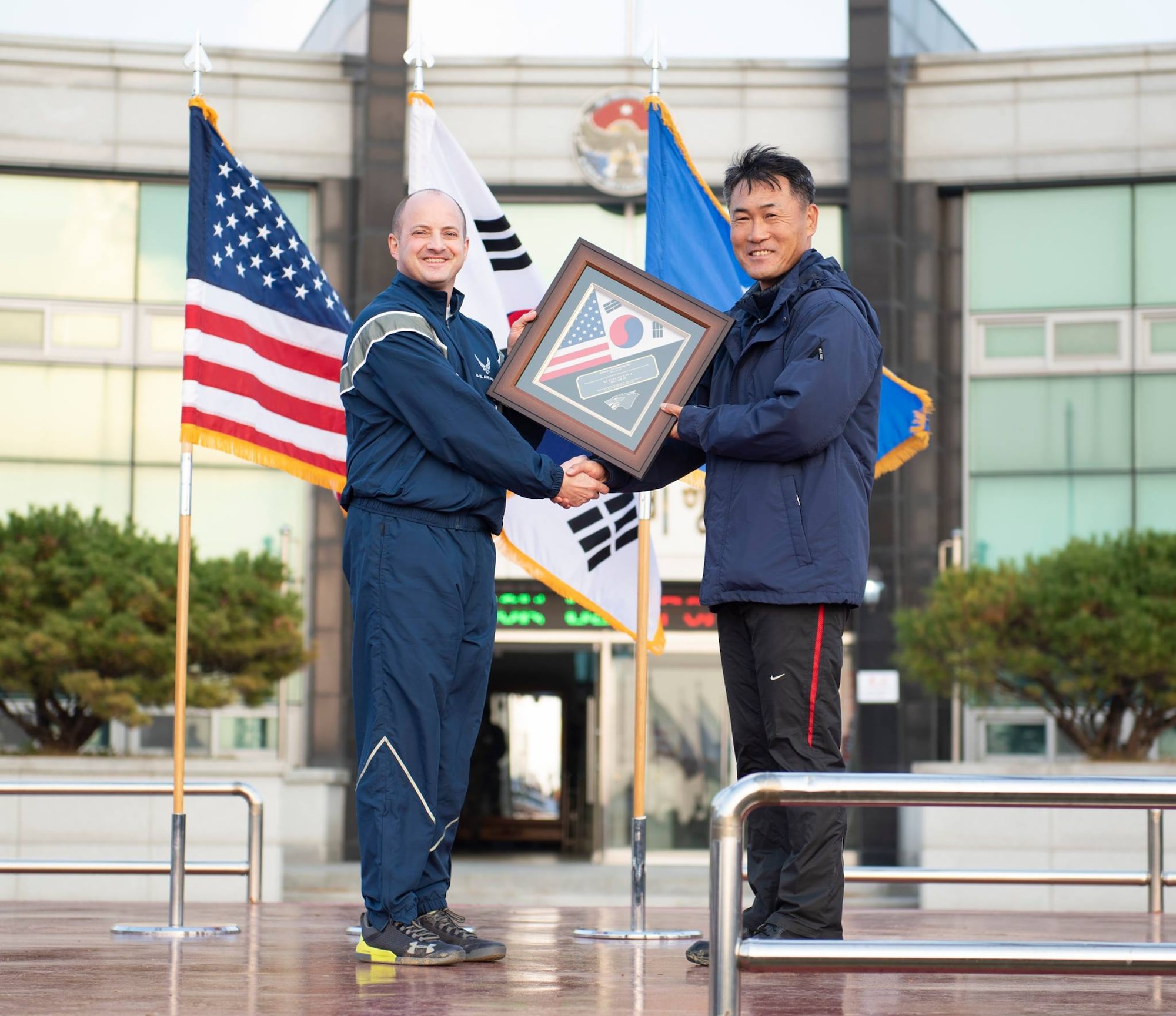 Col. John Bosone, 8th Fighter Wing commander (left), presents Col. Jae-Gyun Jeon, 38th Fighter Group commander (right), with a commemorative plaque at Kunsan Air Base, Republic of Korea, Nov. 9, 2018. The US-ROKAF Friendship Day focused on celebrating the partnership and alliance between the 8th Fighter Wing and 38th Fighter Group, who participated in several sporting events and competitions throughout the day. (U.S. Air Force photo by Senior Airman Stefan Alvarez)