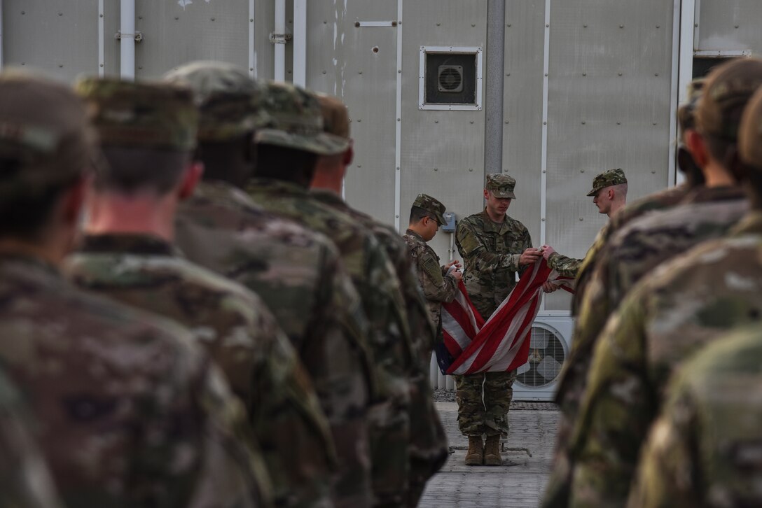 U.S. Airmen fold the flag during a monthly retreat ceremony at Al Dhafra Air Base, United Arab Emirates, Nov. 2, 2018. Retreat ceremonies started back in the Revolutionary War where they signaled the end of the duty day and paid respect to the nation's flag. (U.S. Air Force photo by Senior Airman Mya M. Crosby)