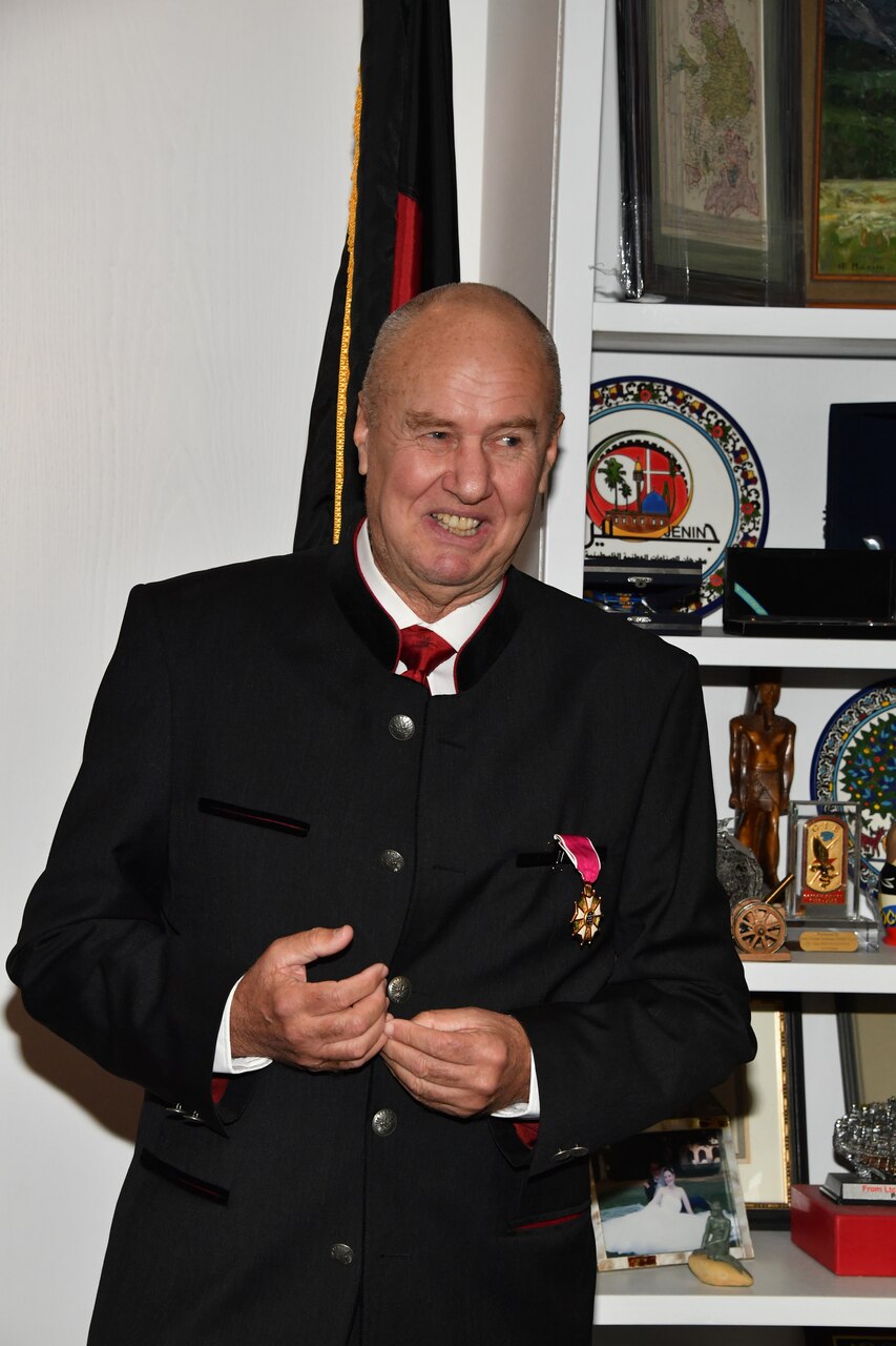 An Austrian army officer in civilian clothes speaks at an award ceremony.