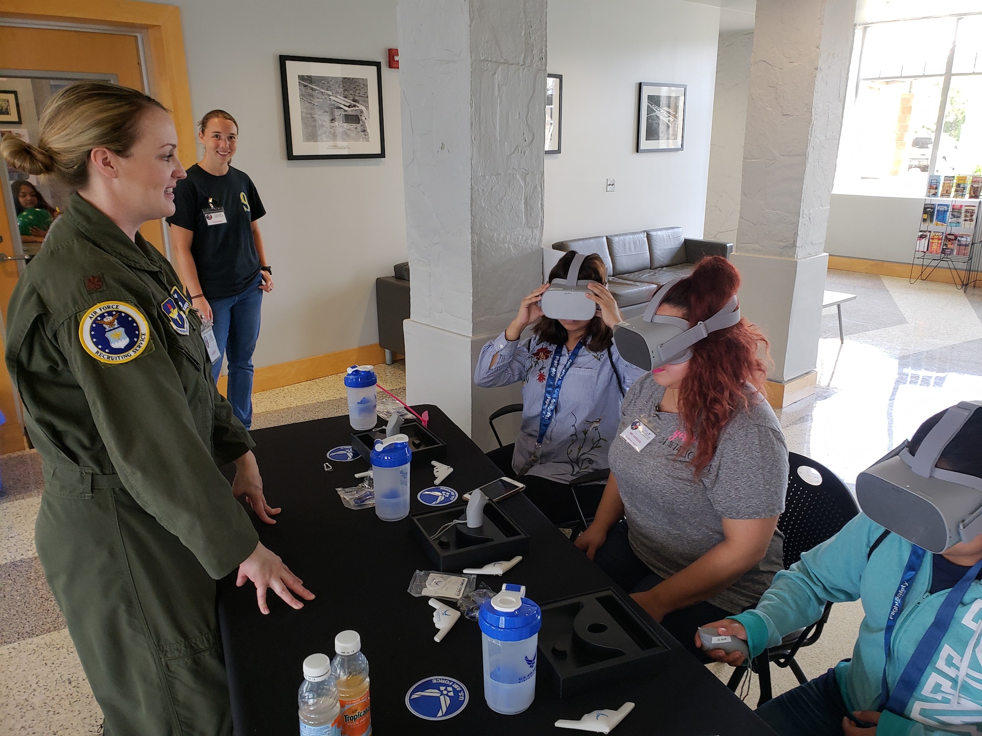 Maj. Lindsay Andrew, AFRS Det. 1 director of operations, demonstrates a VR headset with participants of Girls in Aviation Day.