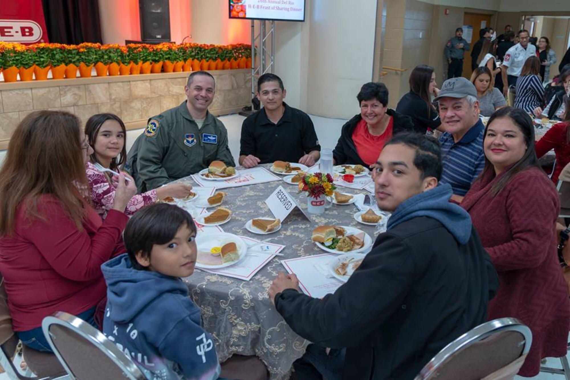 Col. Lee Gentile, 47th Flying Training Wing commander, sits at a table full of attendees at H-E-B’s 26th annual Feast of Sharing, Nov. 11, 2018. The event, which gives a warm, full course Thanksgiving meal to anyone who desired, took time to thank those who help defend, or have defended, this great nation.