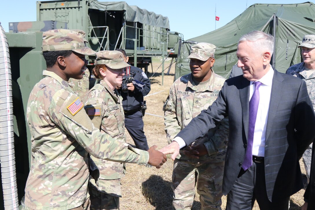 The defense secretary shakes hands with troops