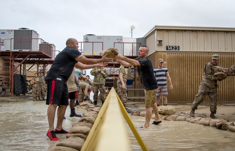 Soldiers pass sandbags to one another while constructing a barrier to divert flood waters away from their living quarters at Camp Arifjan, Kuwait, November 15, 2018. The flooding came after an unusually heavy rainstorm hit the area, which has already experienced significant rain this month.