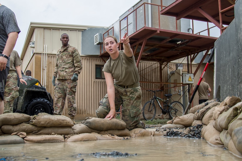 A Soldier directs others where to place sandbags in order to divert flood waters after a rainstorm at Camp Arifjan, Kuwait, November 15, 2018. Soldiers from multiple units joined together to respond to the flooding which had impacted their living quarters.