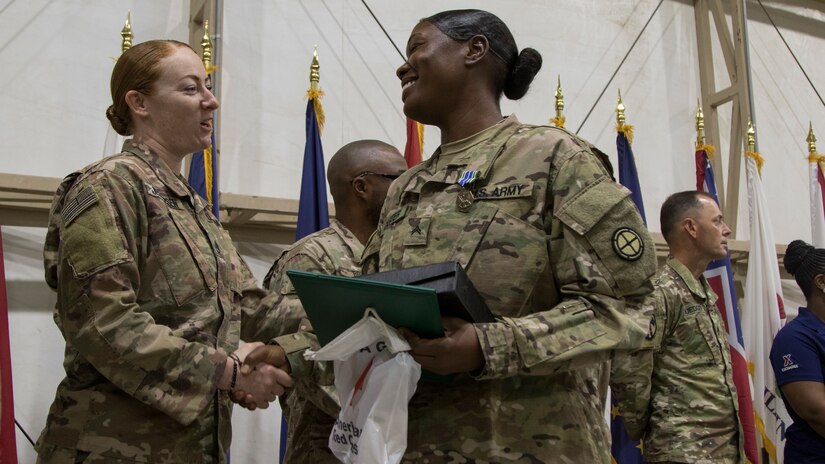 An instructor from the U.S. Army Central Noncommissioned Officer Academy congratulates Cpl. Markitta A. Carter during the graduation ceremony for class 18-710 of the U.S. Army Central Basic Leader Course, Oct. 17, 2018, at Camp Buerhing, Kuwait. The NCOA in Camp Buehring prepares junior Soldiers for leadership positions within their units while deployed overseas.