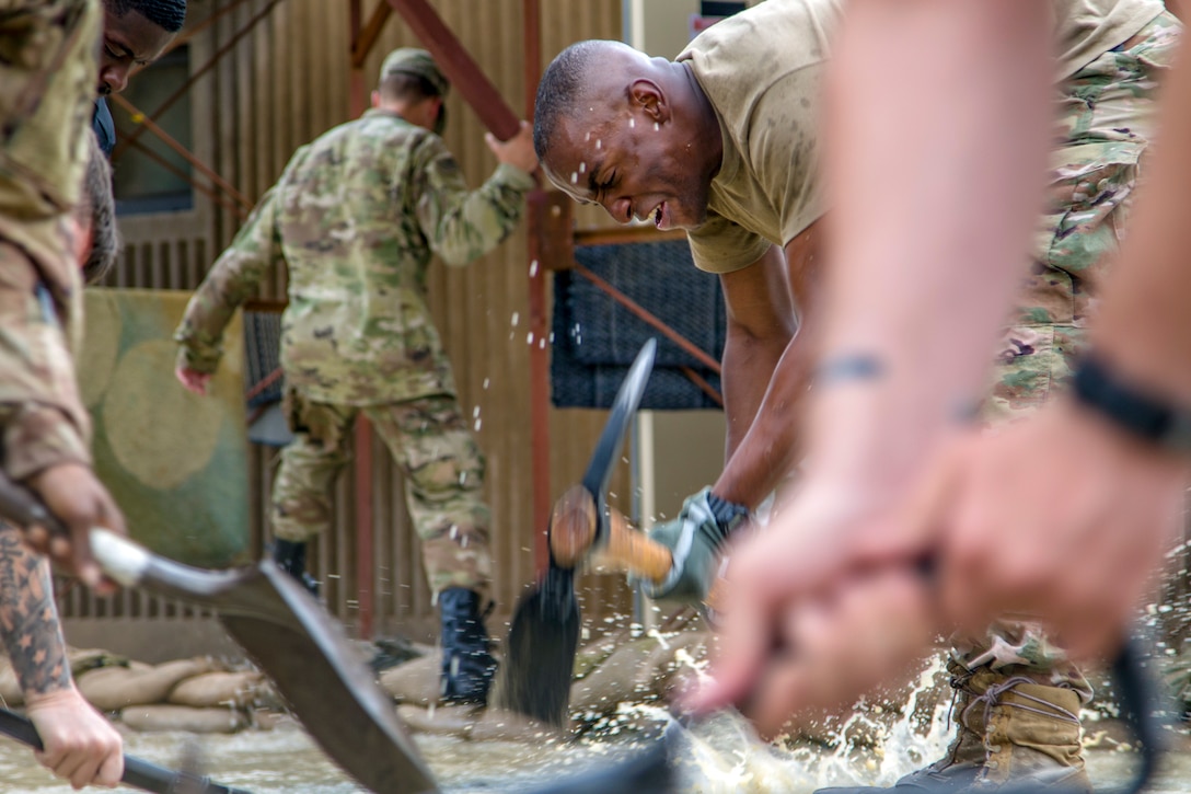 Soldiers work together to divert a flood.