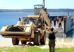 Sailors assigned to Naval Beach Unit (NBU)  7, load a high-mobility excavator from the 1224th Engineering Support Company, Guam Army National Guard, onto Navy Landing Craft, Utility (LCU) 1634 at the Reserve Craft Beach in Guam. NBU-7 and Guam Army National Guard work to together to load 18 heavy equipment vehicles onto the Whidbey-Island class amphibious dock landing ship USS Ashland (LSD 48). Ashland is at Naval Base Guam to transport heavy equipment vehicles to Saipan in support of disaster relief efforts after Super Typhoon Yutu. (U.S. Navy photos by Mass Communication Specialist 1st Class Oliver Cole/Released)