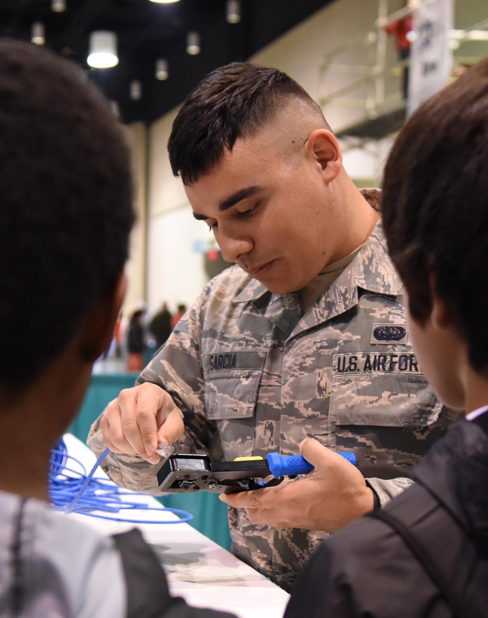 U.S. Air Force Senior Airman Romero Garcia, 81st Communications Squadron client systems technician, provides a demonstration on making cable from scratch to St. Martin Middle School students during the Pathways to Possibilities event at the Mississippi Coast Coliseum in Biloxi, Miss., Nov. 14, 2018. The event is an interactive career expo designed for all eighth graders in private and public schools in the six lower counties of Mississippi. The purpose of the event, set forth by the Mississippi Department of Education, is to help encourage a direction for the students high school pathway choice and is linked to the Common Core state standards. (U.S. Air Force photo by Kemberly Groue)