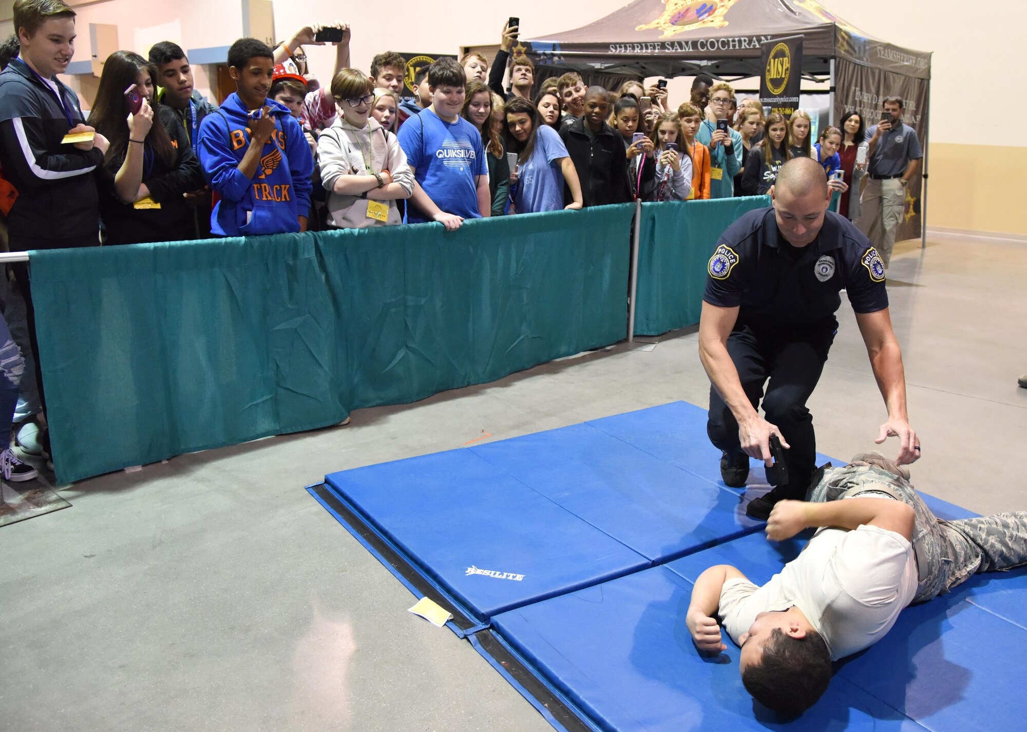 Justin DePew, 81st Security Forces Squadron unit trainer, conducts a stun gun demonstration on U.S. Air Force Senior Airman Daniel Anchondo, 81st Medical Operations Squadron medical technician, during the Pathways to Possibilities event at the Mississippi Coast Coliseum in Biloxi, Miss., Nov. 14, 2018. The event is an interactive career expo designed for all eighth graders in private and public schools in the six lower counties of Mississippi.  (U.S. Air Force photo by Kemberly Groue)