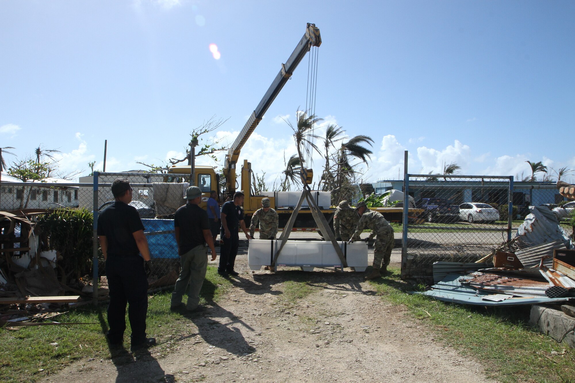 U.S. Army Reserve Soldiers with the 797th Engineer Company (Vertical), 9th Mission Support Command, and personnel with the Department of Fire and Emergency Services offload a FEMA tent as part of the Temporary Emergency Tent and Roofing Installation Support program implemented by the Commonwealth of the Northern Mariana Islands government and the FEMA, at a residency in Koblerville, Saipan, CNMI, Nov. 9, 2018.