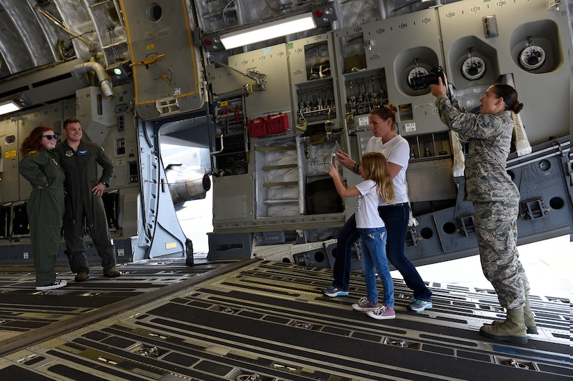 Fallon Emery, a new honorary member of the 437th Operations Support Squadron, poses for photos with 1st Lt. Thad Sollick, a C-17 Globemaster III pilot assigned to the 437th OSS, inside a C-17 Nov. 7, 2018, at Joint Base Charleston, S.C., as part of the Airman for a Day program.