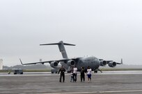 Fallon Emery, second from right, a new honorary member of the 437th Operations Support Squadron, walks on the flight line with 1st Lt. Thad Sollick, left, a C-17 Globemaster III pilot assigned to the 437th OSS, Nov. 7, 2018, after touring a C-17 at Joint Base Charleston, S.C., as part of the Airman for a Day program.