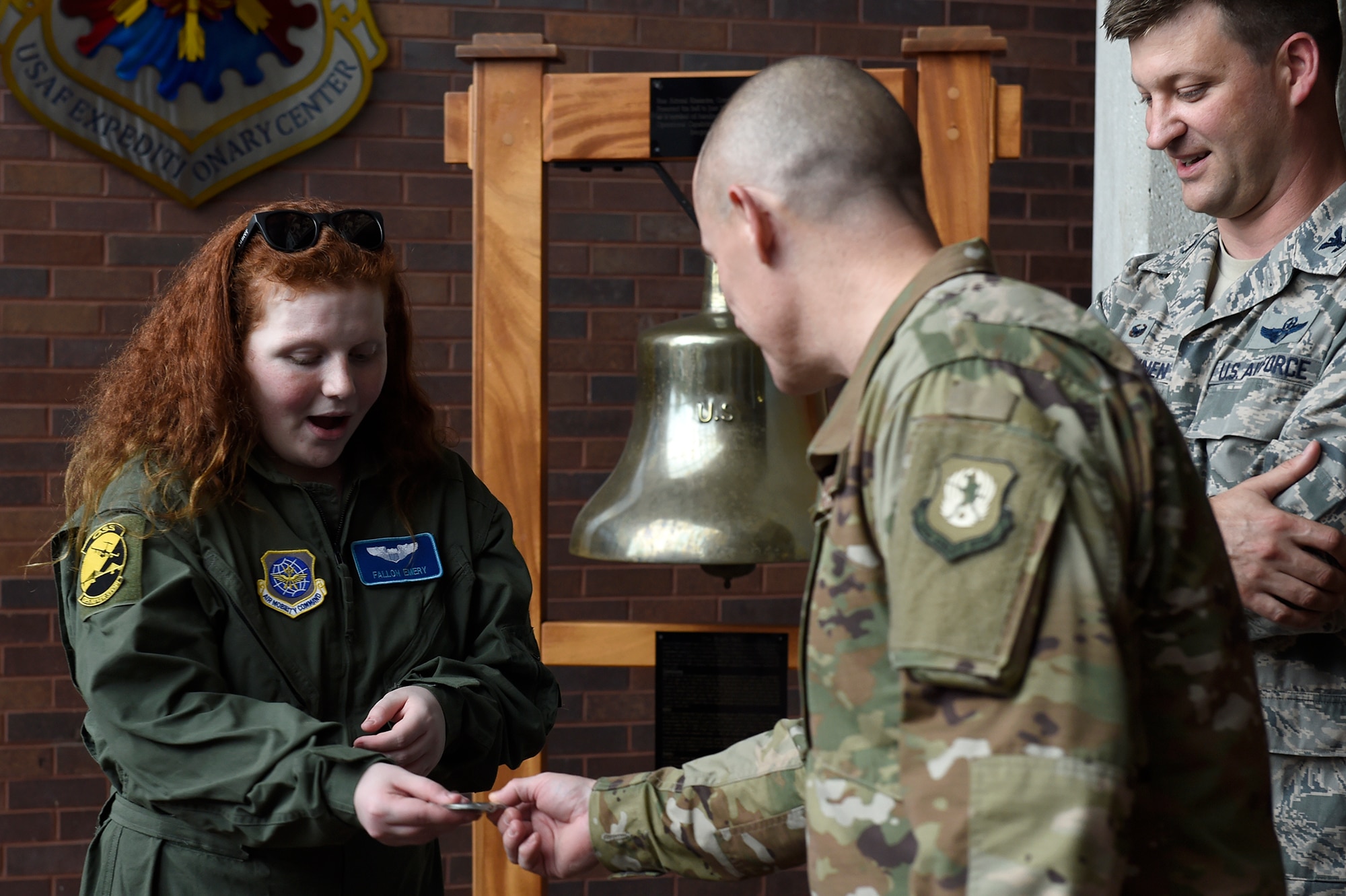 Fallon Emery, a new honorary member of the 437th Operations Support Squadron, accepts a challenge coin from Chief Master Sgt. Ronnie Phillips, 437th Airlift Wing command chief master sergeant, Nov. 7, 2018, at Joint Base Charleston, S.C., as part of the Airman for a Day program.