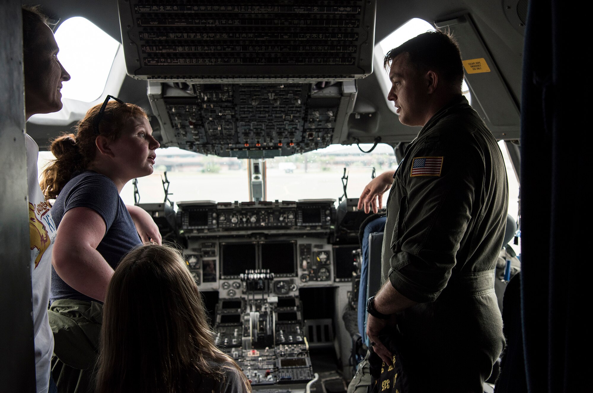 1st Lt. Thad Sollick, a C-17 pilot assigned to the 437th Operations Support Squadron, briefs Fallon Emery, a new honorary member of the 437th OSS, and her family inside the cockpit of a C-17 Globemaster III aircraft Nov. 7, 2018, at Joint Base Charleston, S.C., as part of the Airman for a Day program.