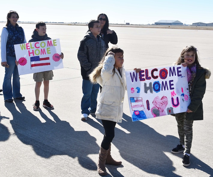 Family members of 931st Air Refueling Wing members hold homemade signs as they await the return of their loved ones Nov. 15, 2018, McConnell Air Force Base, Kan. More than 35 members of the 931 ARW returned from a deployment to Turkey.