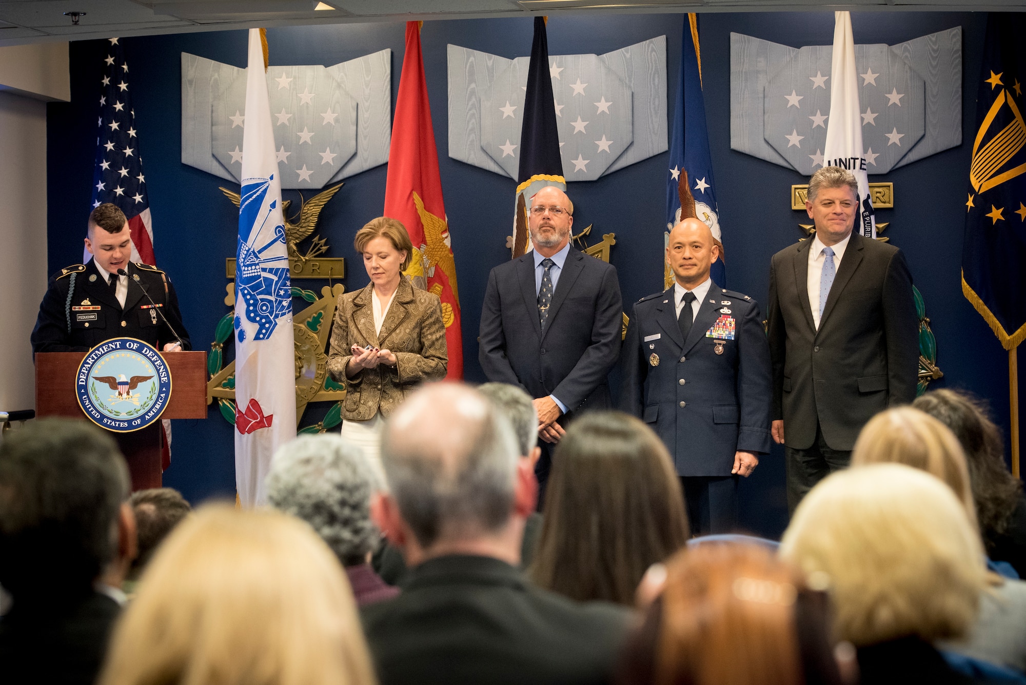 Five people on a stage reading a citation.