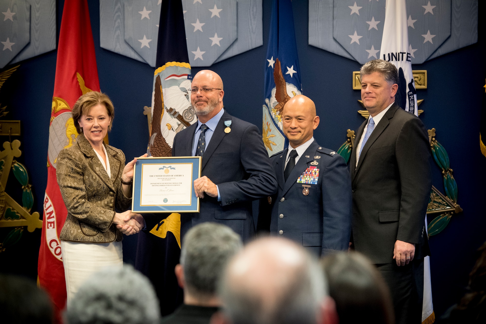 Four people at a ceremony holding an award