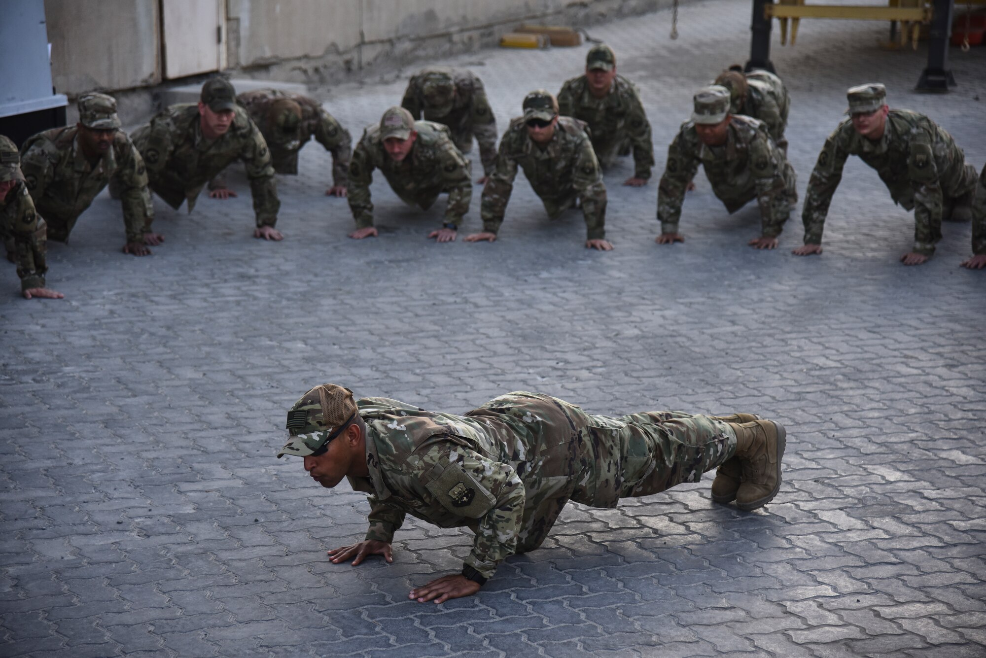 U.S. Air Force Master Sgt. Jason Napoleoni, 380th Expeditionary Logistics Readiness Squadron ground transportation superintendent, and 380 ELRS Airmen execute 4-count push-ups during a tribute to the fallen ground transportation Airmen at Al Dhafra Air Base, United Arab Emirates, Nov. 8, 2018. The 380th ELRS takes the time every Thursday to make sure that the lives and legacies of the fallen Airmen continue to prevail. (U.S. Air Force photo by Senior Airman Mya M. Crosby)