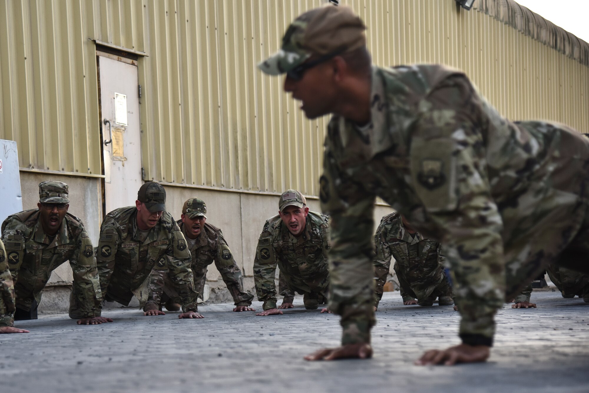 U.S. Airmen assigned to the 380th Epeditionary Logistics Readiness Squadron execute 4-count push-ups during a tribute to the fallen ground transportation Airmen at Al Dhafra Air Base, United Arab Emirates, Nov. 8, 2018. The 380th ELRS takes the time every Thursday to make sure that the lives and legacies of the fallen Airmen continue to prevail. (U.S. Air Force photo by Senior Airman Mya M. Crosby)