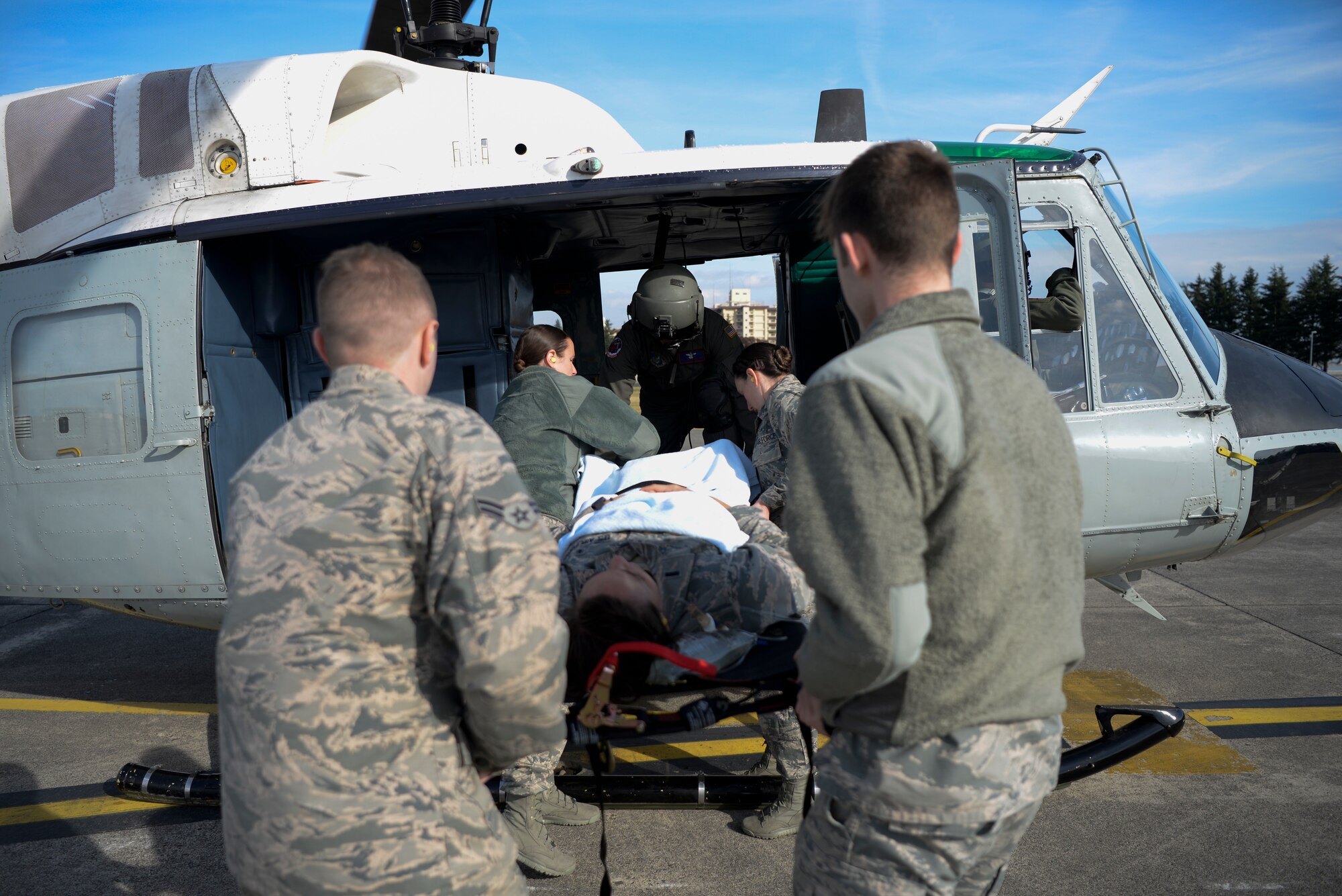 Members of the 374th Medical Group and the 459th Airlift Squadron load a patient into a UH-1N Iroquois during training, Nov. 16, 2018, at Yokota Air Base, Japan.