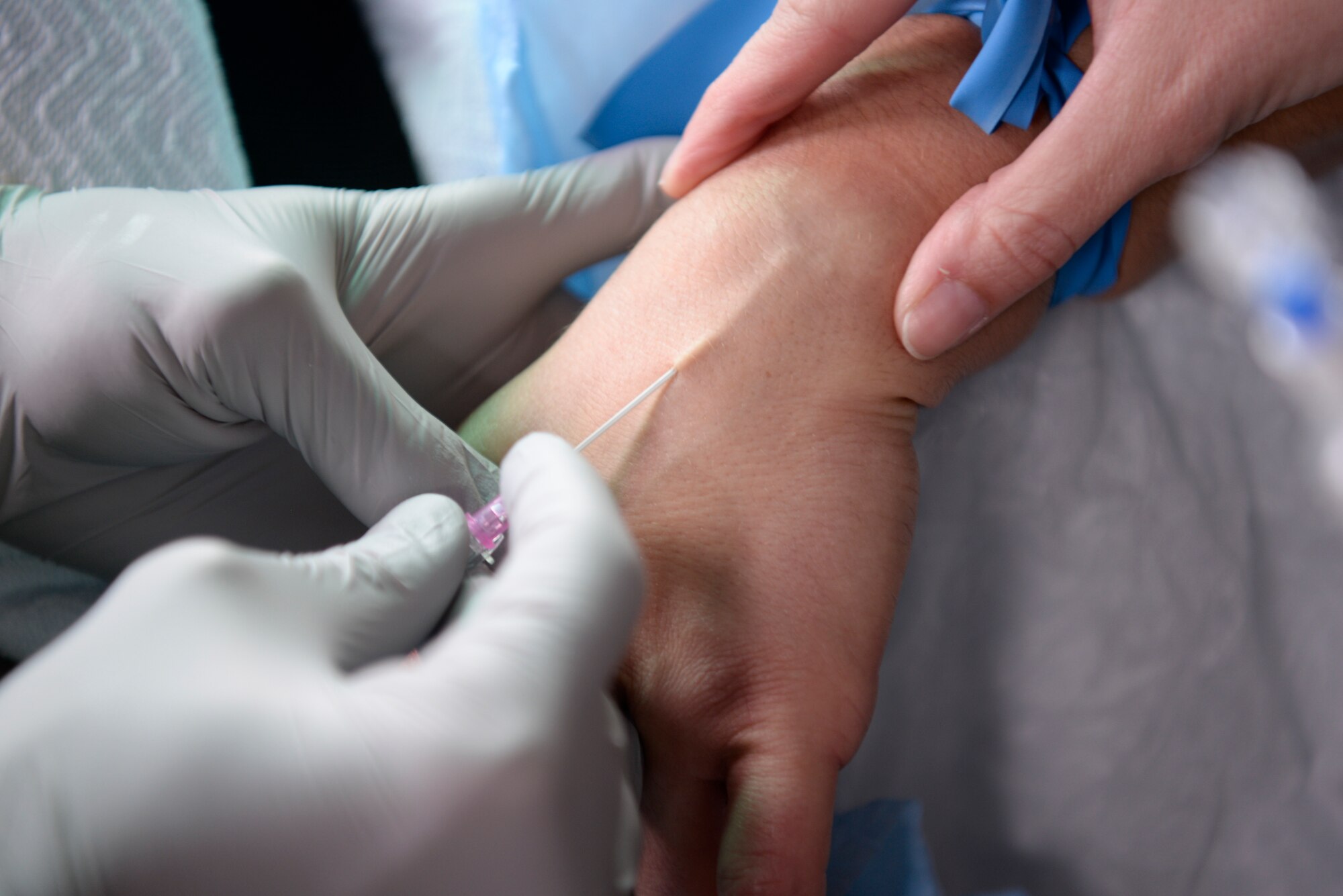 Members of the 374th Medical Group inserts an Intravenous Therapy (IV) needle in the hand of a patient, Nov. 16, 2018, at Yokota Air Base, Japan.