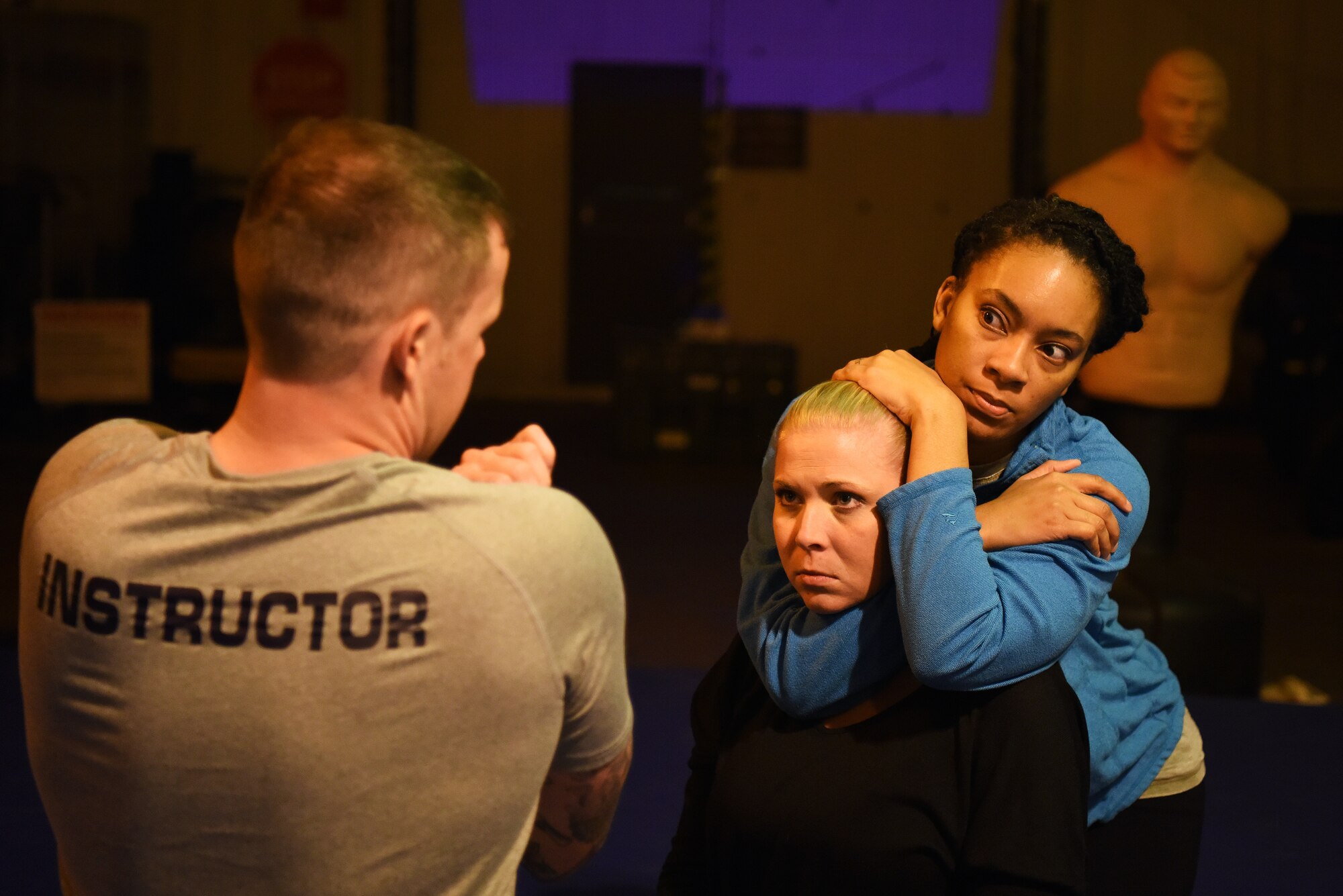 Attendees of a self-defense class learn how to execute a choke hold by Survival, Evasion, Resistance and Escape specialist, assigned to the 48th Operation Support Squadron, on Royal Air Force Mildenhall, England, Nov. 14, 2018. The SERE specialist and instructor of the class, explained the different types of chokes and the effect they may have on attackers. (U.S. Air Force photo by Airman 1st Class Shanice Williams-Jones)