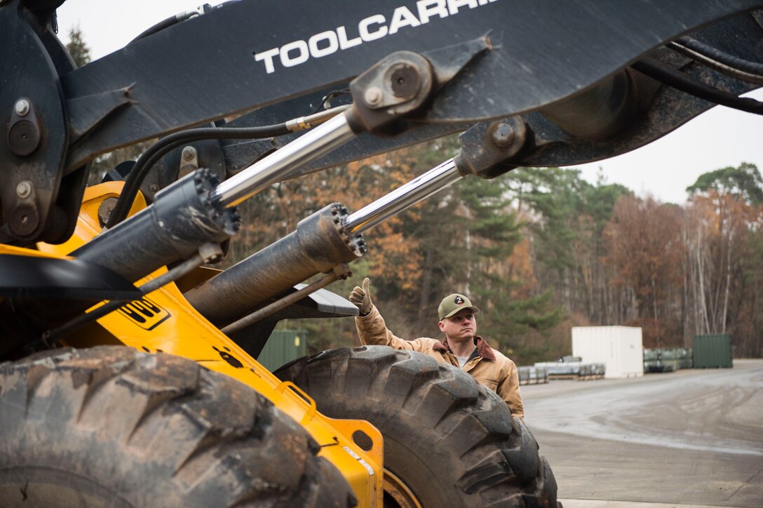 U.S. Air Force Tech. Sgt. Brock Butschke, 435th Construction and Training Squadron pavements and equipment contingency instructor, gives signals to a front loader operator during a civil engineer training event on Ramstein Air Base, Germany, Nov. 15, 2018. The 786th Civil Engineer Squadron reached out to the 435th CTS to assist with its Prime Base Engineer Emergency Force training. (U.S. Air Force photo by Senior Airman Joshua Magbanua)