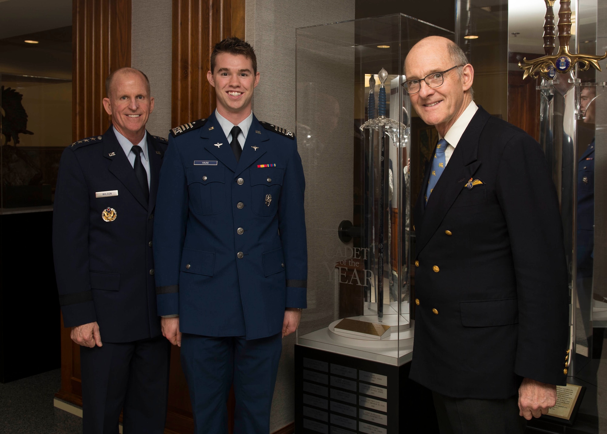 Air Force Vice Chief of Staff Gen. Stephen V. Wilson, Cadet 2nd Class Kyle Haak and Dr. The Hon. Gilbert Greenall, Commodore of the Royal Air Squadron, pose for a photo in front of the Millennium Sword at the Pentagon, Arlington, Va., Nov. 6, 2018. Haak was honored as the British Air Squadron’s 2018 Cadet of the Year. Recipients of the award receive the Millennium Sword, which is kept on permanent display in the Pentagon. (U.S. Air Force photo by Staff Sgt. Victoria H. Taylor)