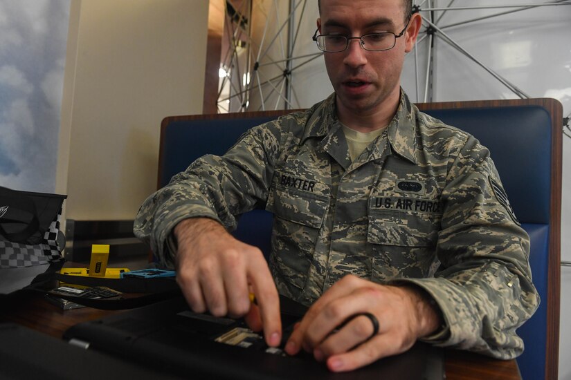 U.S. Air Force Staff Sgt. Matthew Baxter, Air Combat Command Communication Support Squadron global command and control systems administrator, takes apart a personal computer before recycling it during America Recycles Day at Joint Base Langley-Eustis, Virginia, Nov. 15, 2018. The 633rd CES held a recycling event at the Base Exchange to collect grocery bags, electronics and plastics. (U.S. Air Force photo by Senior Airman Derek Seifert)