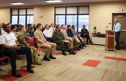 A group of Naval War College students, comprised of 56 foreign and joint military officers, listen to a mission briefing during a Nov. 13, 2018, visit to Joint Base Charleston, S.C.
