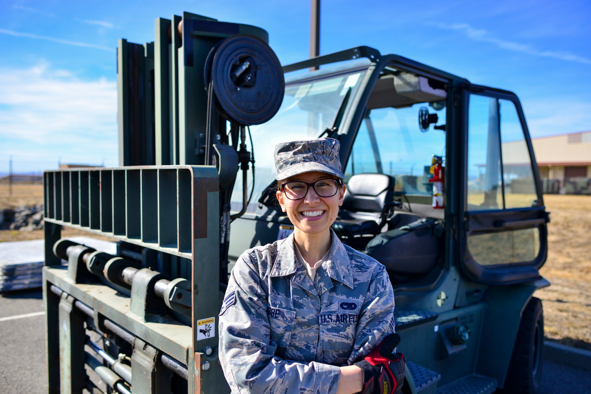 Senior Airman Catherine Lubbe, 55th Aerial Port Squadron special handling representative, poses for a photo in front of a forklift Nov. 4, 2018 at Travis Air Force Base, California.