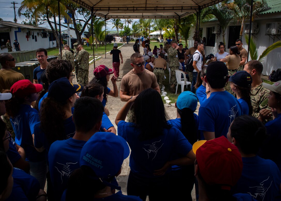 Lt. Cmdr. Paul Roszko, from Portsmouth, Va. and officer in charge at a land-based medical site, briefs volunteer translators from local universities.