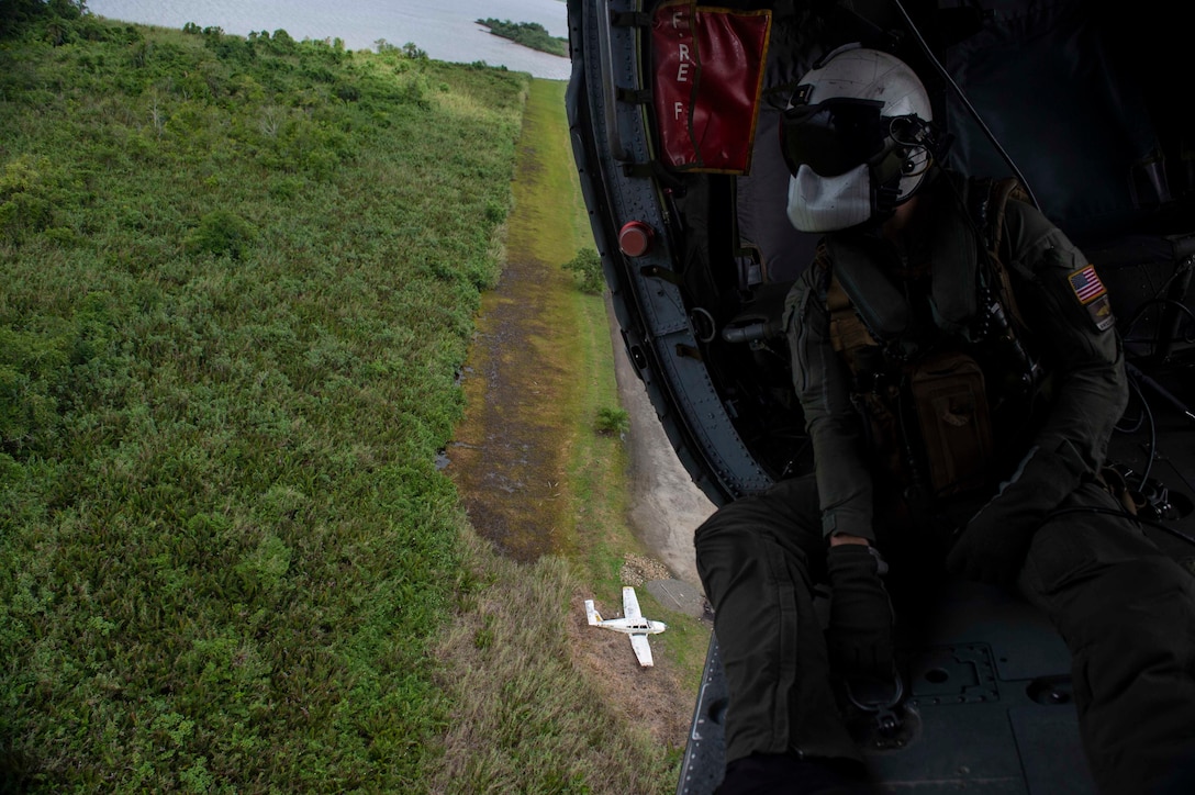 Naval Aircrewman (Helicopter) 2nd Class Nicholas Glass, from Salisbury, N.C., looks out across the Colombian landscape from aboard an MH-60S Seahawk.