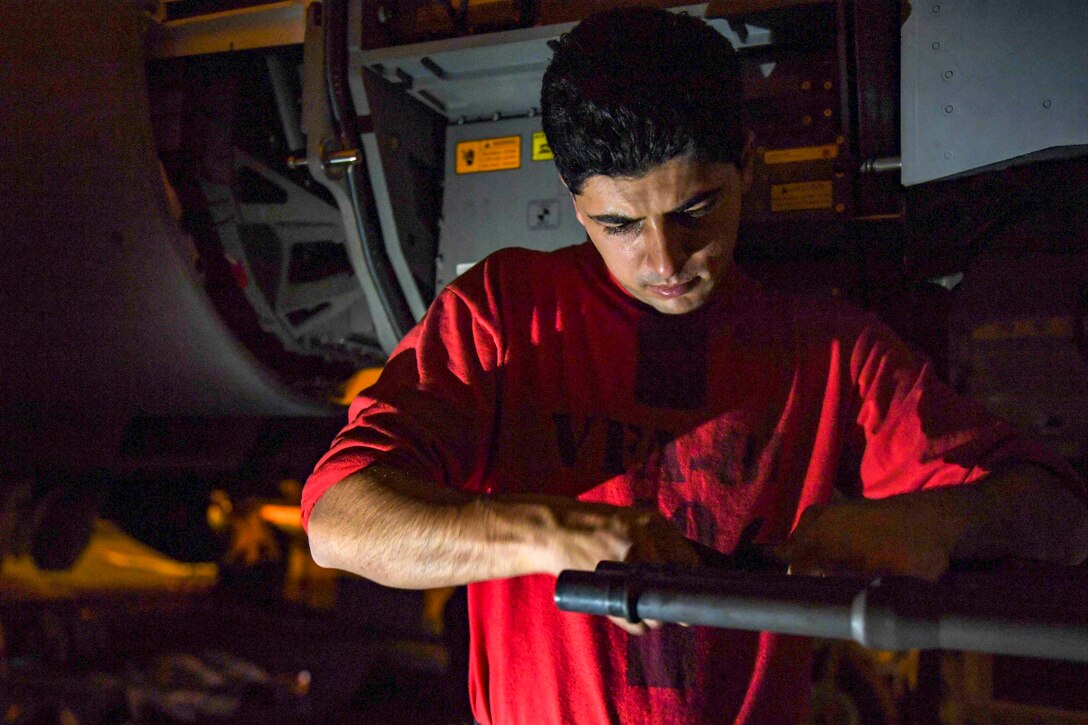 A sailor cleans a weapon.