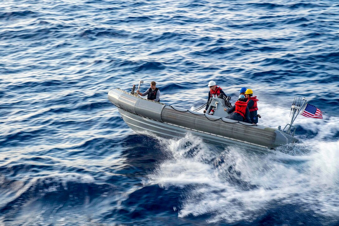 Sailors ride in an inflatable boat.