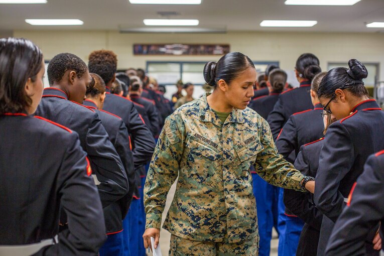 A Marine inspects the dress blues of a graduating company.
