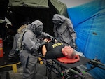 A decontamination team of Airmen and Soldiers care for casualties in a simulated mass casualty decontamination line during the 503rd Military Police Battalion field training exercise at Camp Blanding, Fla., on Oct. 24, 2018. Army Maj. Gen. William “Bill” Hall participates as a mock victim of a chemical, biological, radiological and nuclear catastrophe. (Courtesy photo by Navy Chief Petty Officer Zach McKinley)