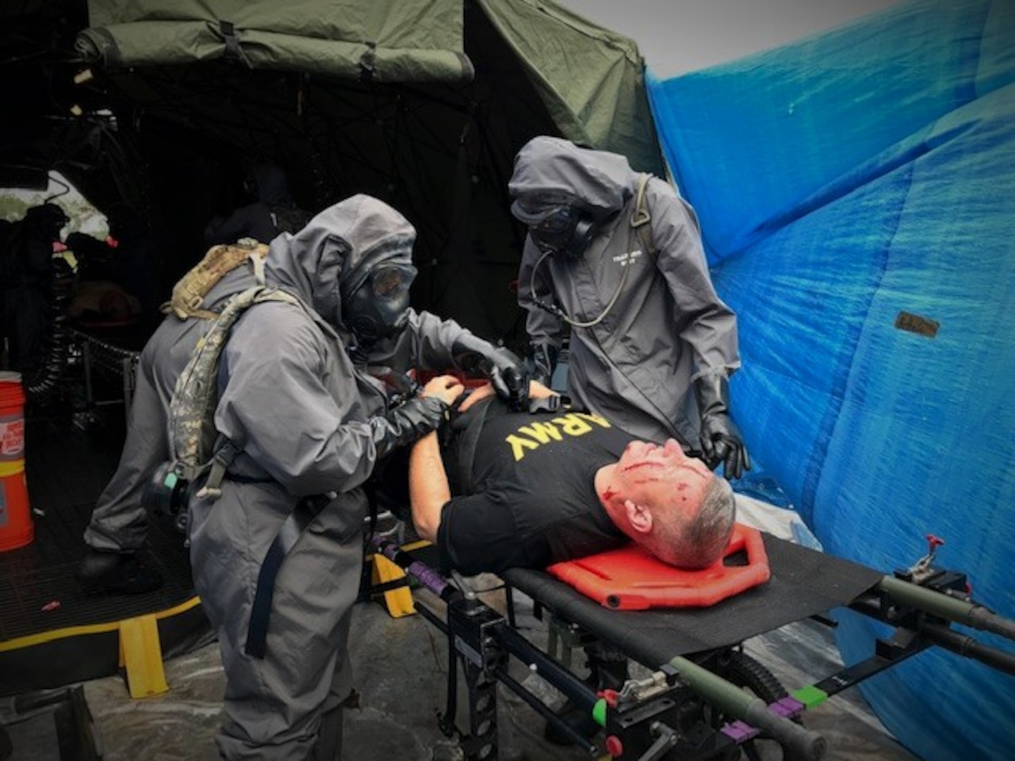 A decontamination team of Airmen and Soldiers care for casualties in a simulated mass casualty decontamination line during the 503rd Military Police Battalion field training exercise at Camp Blanding, Fla., on Oct. 24, 2018. Army Maj. Gen. William “Bill” Hall participates as a mock victim of a chemical, biological, radiological and nuclear catastrophe. (Courtesy photo by Navy Chief Petty Officer Zach McKinley)