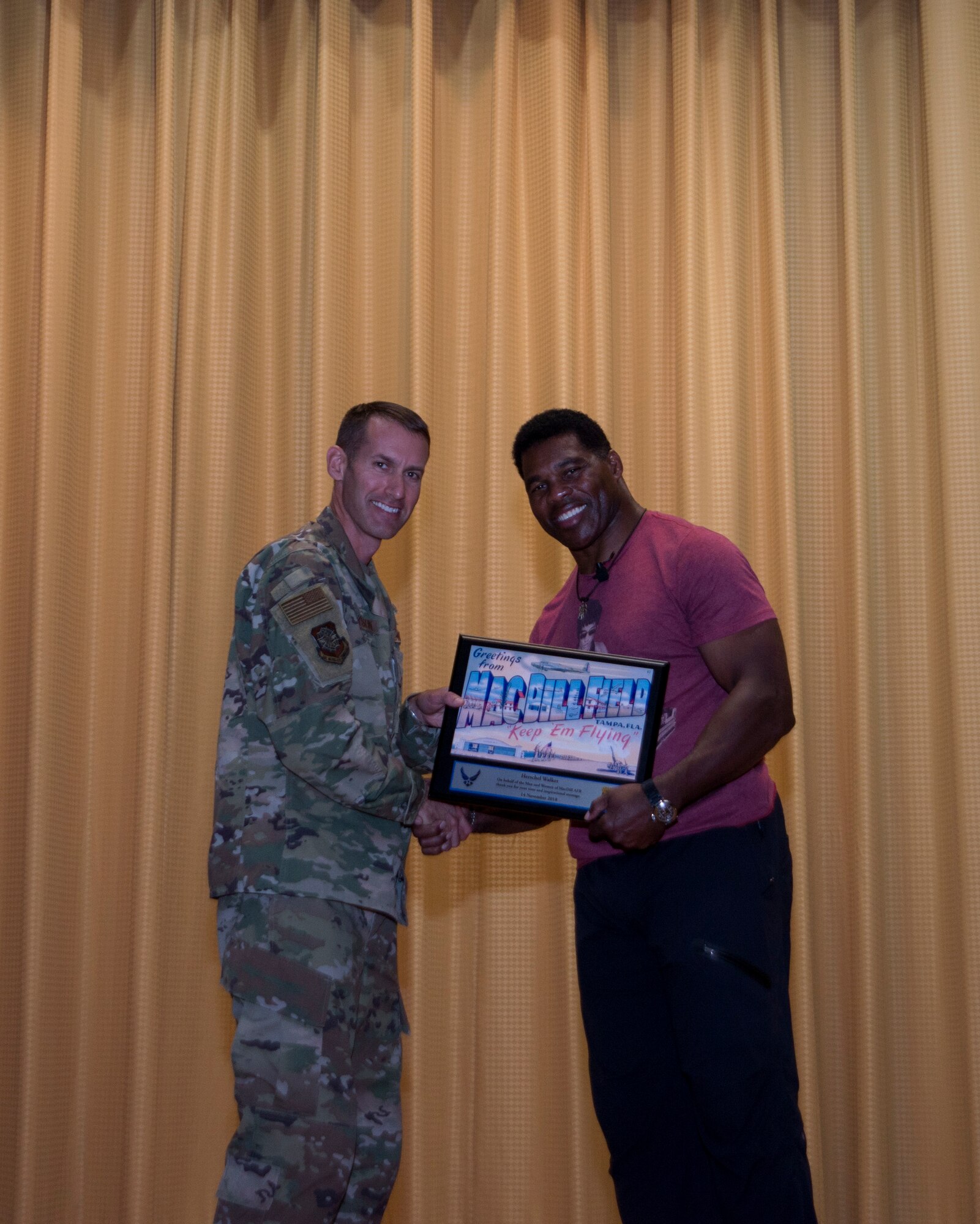 Former NFL running back Herschel Walker receives a token of appreciation from U.S. Air Force Colonel Stephen Snelson, 6th Air Mobility Wing Commander, at MacDill Air Force Base, Fla., Nov. 14, 2018.