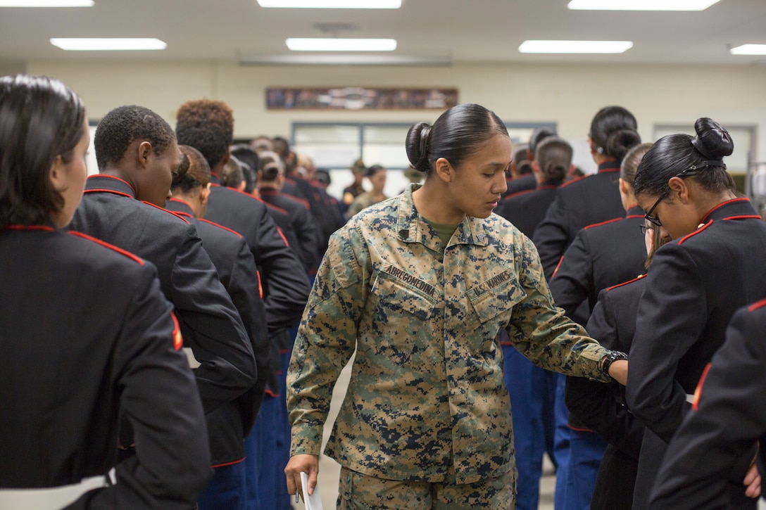 Sgt. Cristal Abregomedina, a warehouse clerk with Headquarters and Service Battalion, examines the uniforms of Marines from November Company, 4th Recruit Training Battalion Nov. 9, 2018 at Marine Corps Recruit Depot Parris Island, S.C.