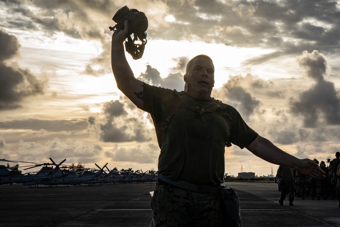 Sgt. Maj. Frank Gratacos, sergeant major, Marine Aircraft Group 24, signals Marines to remove their gas masks after passing him during a gas mask run, Marine Corps Air Station, Kaneohe Bay, Nov. 16, 2018. The physical training event aimed to build unit readiness and cohesion, while also familiarizing Marines with conducting strenuous activity while wearing their gas masks.