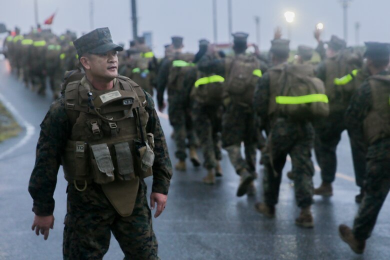 Master Chief Leonardo E. Carbonel motivates Sailors with 3rd Dental Battalion, 3rd Marine Logistics Group, during a 3-mile hike Nov. 16, 2018 at Camp Hansen, Okinawa, Japan. 3rd Dental Battalion Sailors participated in a 3-mile conditioning hike to simulate hiking with deployed Marines and traveling to a Role II facility, as well as conducting Tactical Combat Casualty Care upon arrival. Carbonel, a native of Lemoore, California, is the command master chief for 3rd Dental Battalion. (U.S. Marine Corps photo by Lance Cpl. Armando Elizalde)