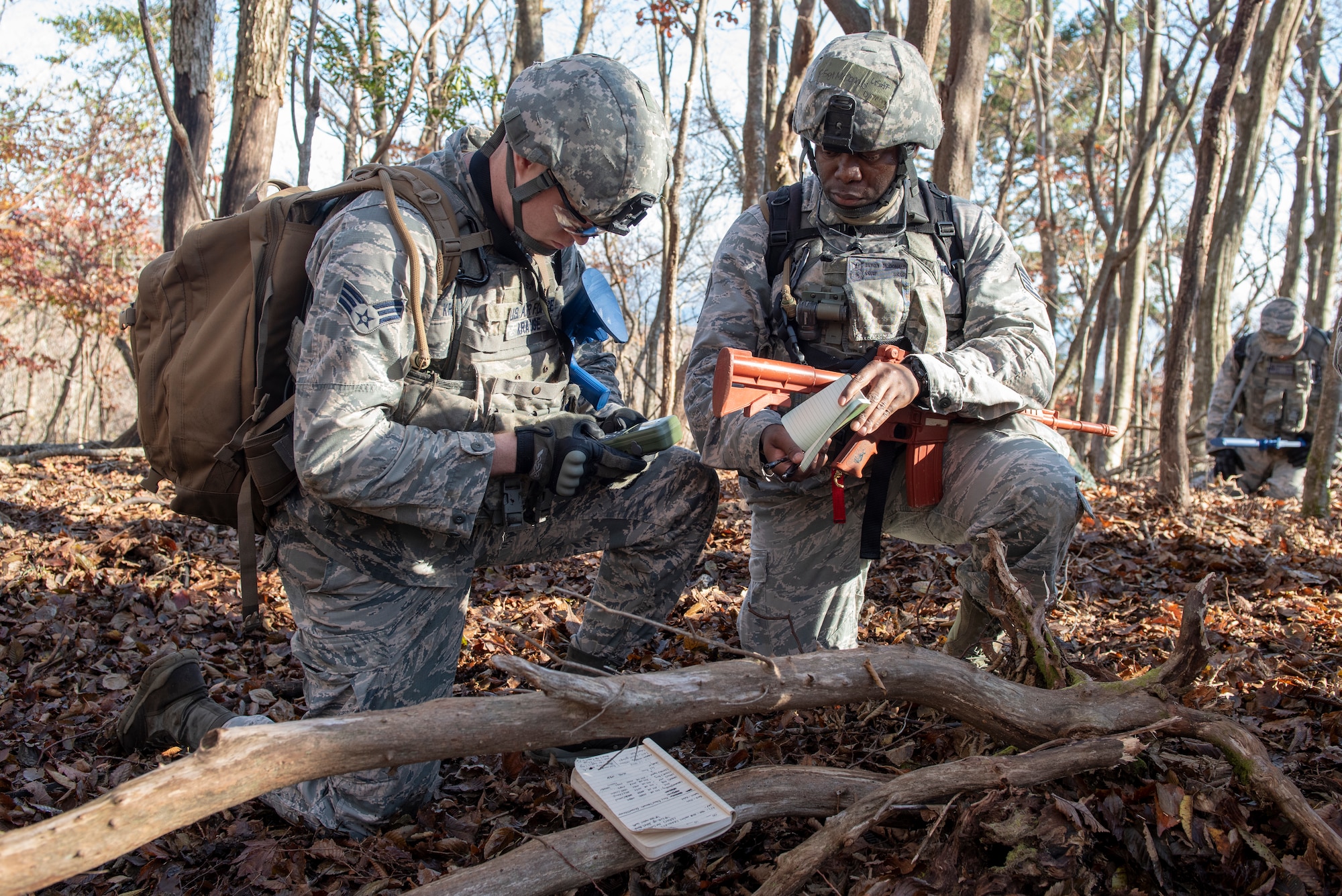 Senior Airman Mitchell Krause, 374th Security Forces Squadron patrolman, left, and Staff Sgt. Rayon McDonald 374 SFS flight chief, right, utilize a Defense Advanced GPS Receiver (DAGR) to mark coordinates in a notebook during a field training exercise at Camp Fuji, Japan, Nov. 8, 2018.