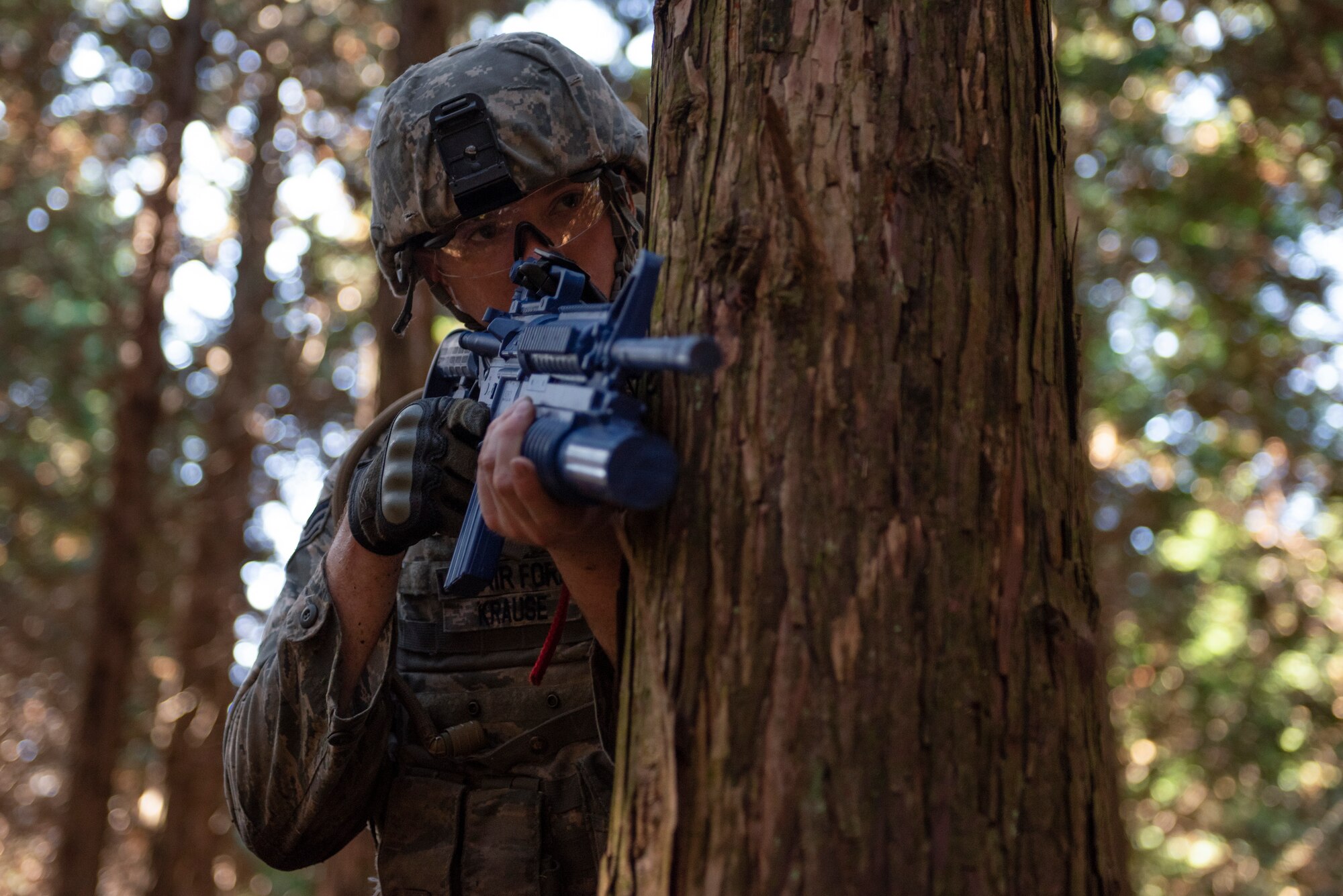 Senior Airman Mitchell Krause, 374th Security Forces Squadron patrolman, takes cover behind a tree during a field training exercise at Camp Fuji, Japan, Nov. 8, 2018.
