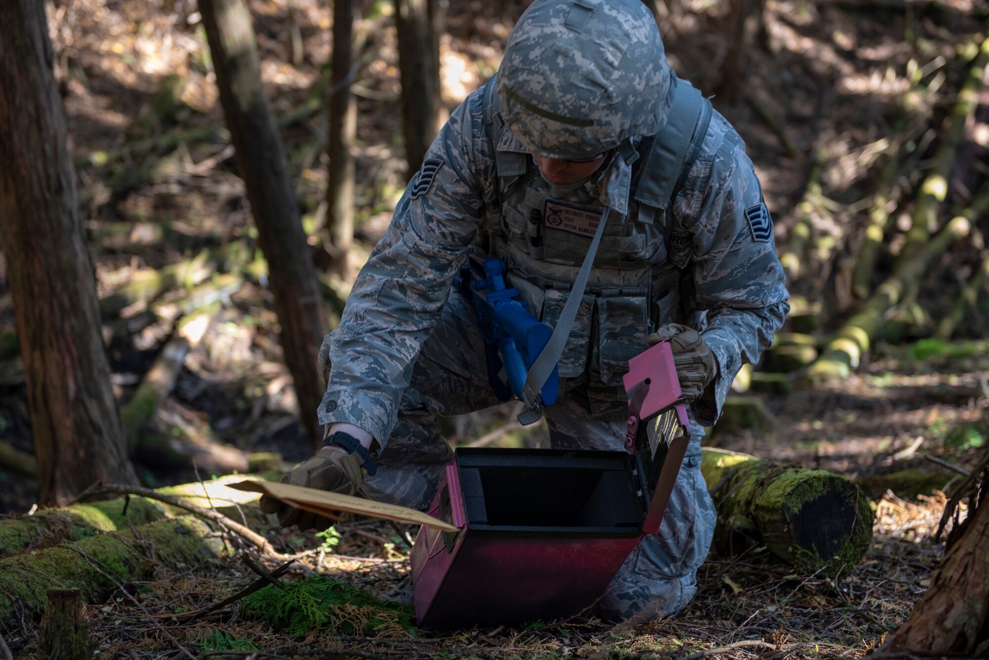 U.S. Air Force Tech. Sgt. Justin Hamilton, 374th Security Forces Squadron flight chief, opens a container holding intelligence information marking the completion of his team’s first objective during a field training exercise at Camp Fuji, Japan, Nov. 8, 2018.