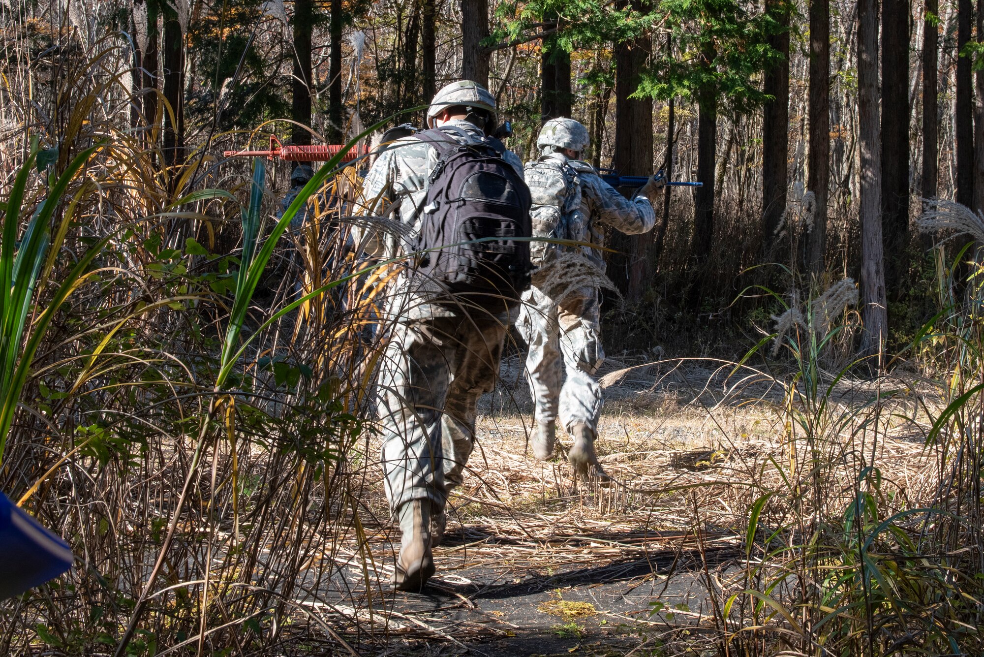 A pair of Airmen from the 374th Security Forces Squadron each cover a side as they pass through an open crossing during a field training exercise at Camp Fuji, Japan, Nov. 8, 2018.