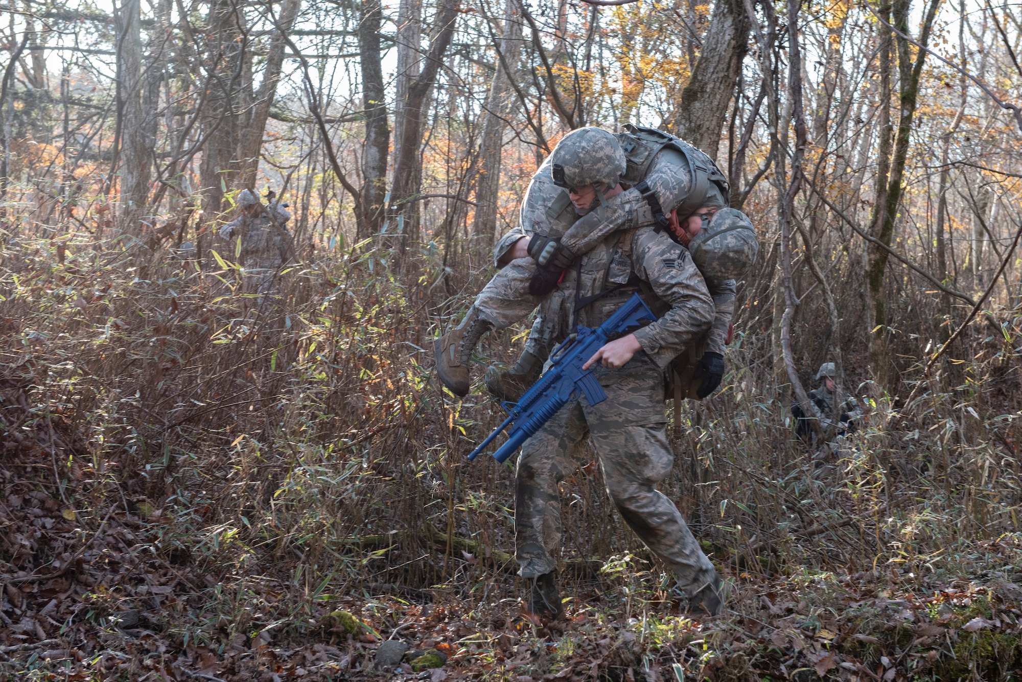 An Airman with the 374th Security Forces Squadron carries his fellow teammate with a simulated injury out of a danger area during a field training exercise at Camp Fuji, Japan, Nov. 8, 2018.