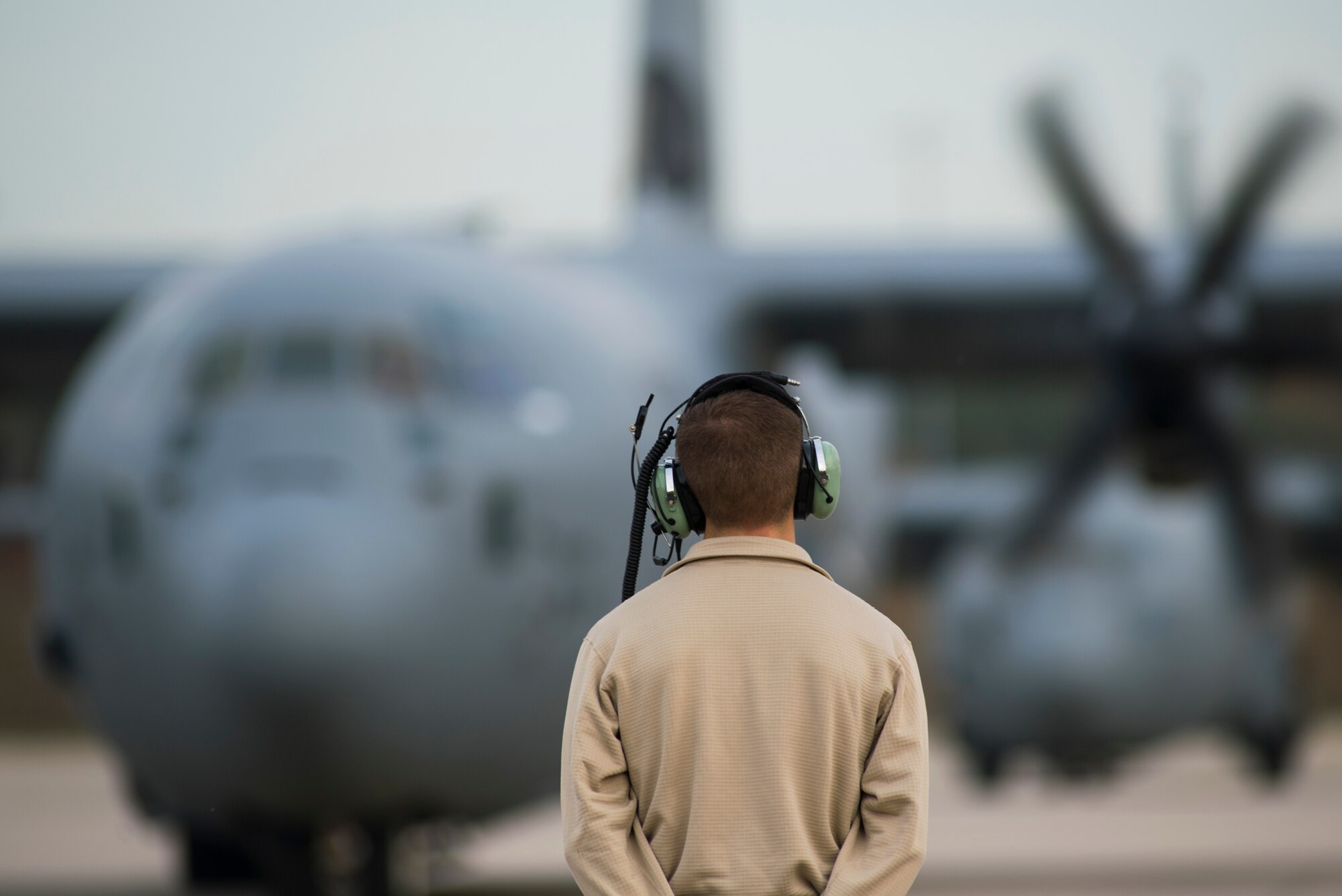 An 86th Aircraft Maintenance Squadron crew chief stands ready as a C-130J Super Hercules aircraft begins start up procedures on Ramstein Air Base, Germany, Nov. 6, 2018. Crew chiefs are responsible for the aircraft on the ground while aircrew responsible for the aircraft during missions. (U.S. Air Force photo by Senior Airman Devin M. Rumbaugh)